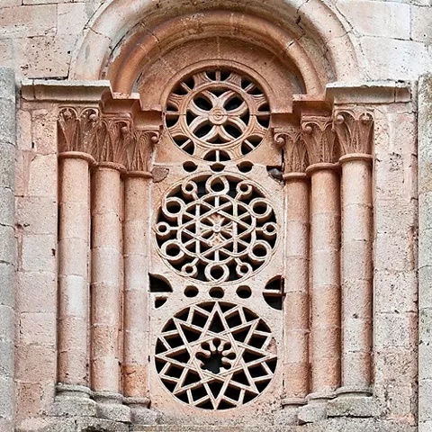 Ventana románica con rosetones de piedra.