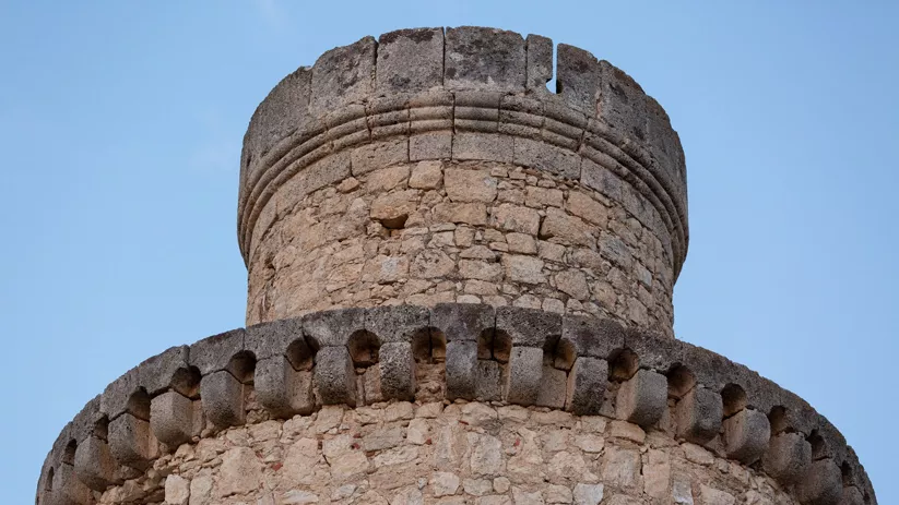 Detalle de torre circular con almenas de piedra