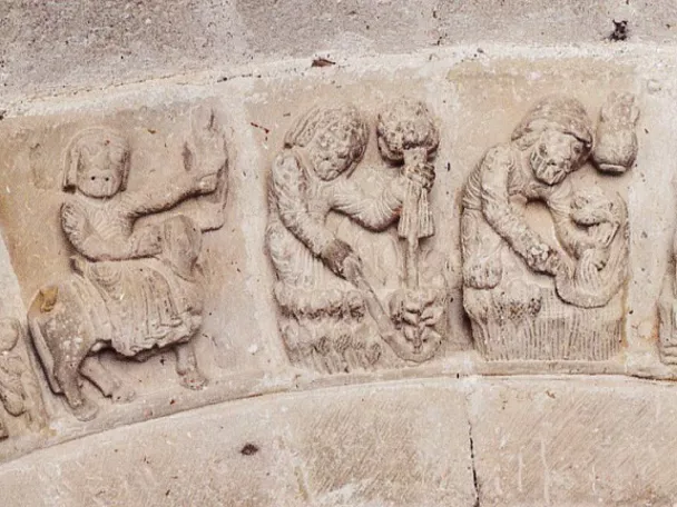 Relieves románicos con escenas simbólicas talladas en piedra.