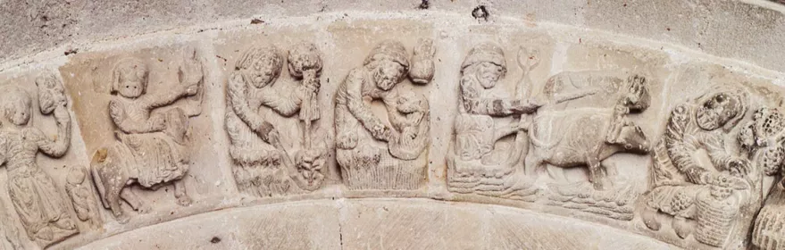 Relieves románicos con escenas simbólicas talladas en piedra.