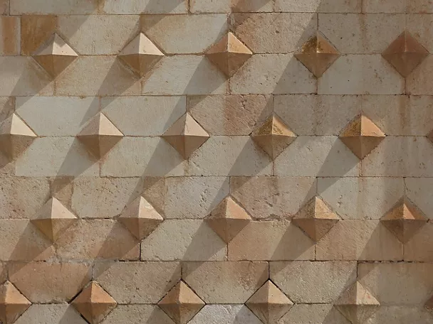 Fachada histórica con relieves geométricos en piedra.