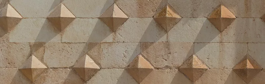 Fachada histórica con relieves geométricos en piedra.