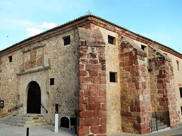 Edificio histórico de piedra con portada monumental y contrafuertes