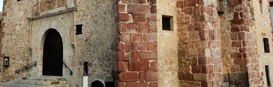 Edificio histórico de piedra con portada monumental y contrafuertes