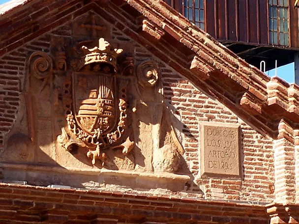 Fachada histórica de ladrillo con escudo tallado