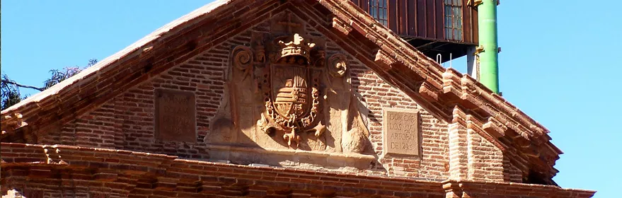 Fachada histórica de ladrillo con escudo tallado