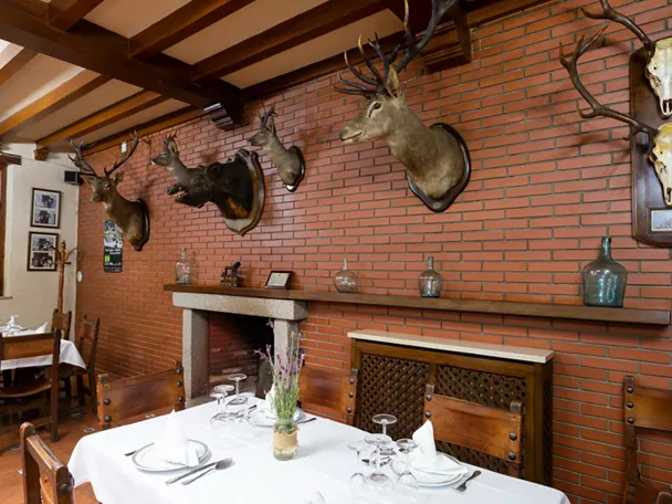 Salón rústico con cabezas de caza en pared de ladrillo