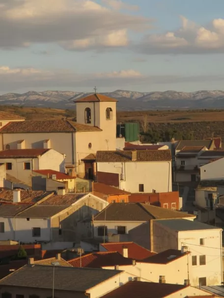 Vista del núcleo urbano con iglesia y tejados al atardecer