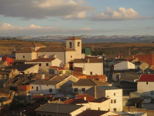 Vista del núcleo urbano con iglesia y tejados al atardecer
