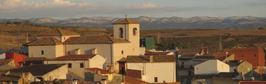 Vista del núcleo urbano con iglesia y tejados al atardecer