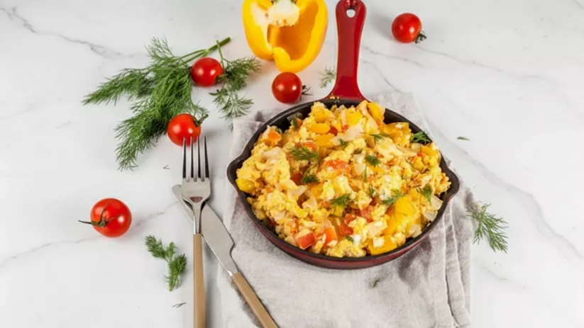 Revuelto casero con verduras frescas presentado en pequeña sartén