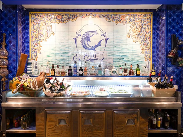 Barra con azulejos marinos y botellas alineadas