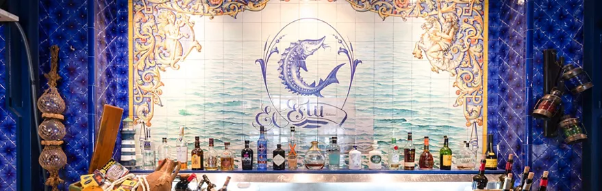 Barra con azulejos marinos y botellas alineadas