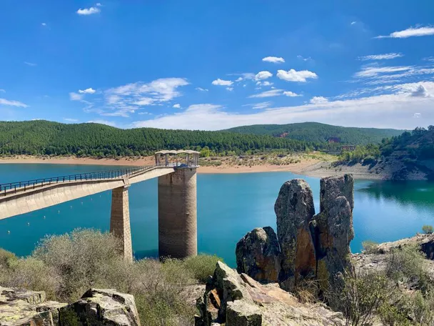 Embalse con presa y pasarela elevada.