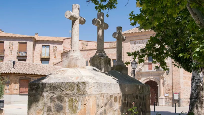 Monumento de cruces de piedra frente a iglesia