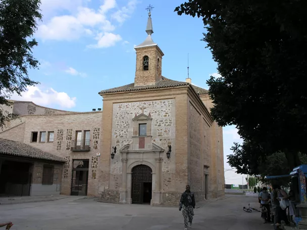 Iglesia de piedra en plaza con árboles