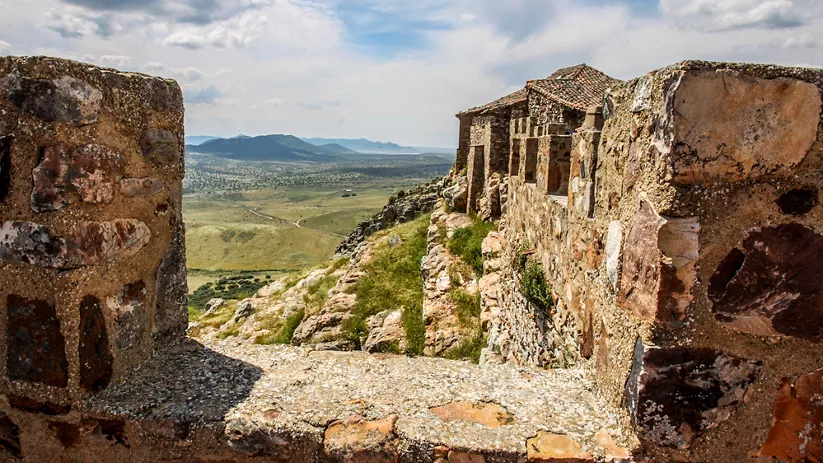 Restos de la ermita en el castillo con paisaje de campo al fondo