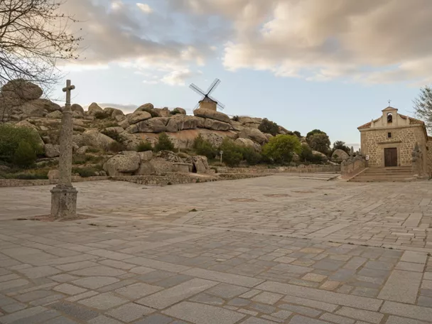 Plaza de piedra con cruz, molino y ermita
