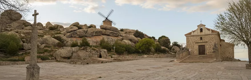 Plaza de piedra con cruz, molino y ermita