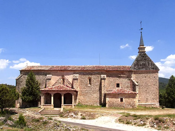 Iglesia de piedra con torre y pórtico.