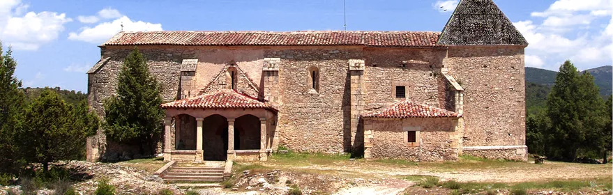 Iglesia de piedra con torre y pórtico.
