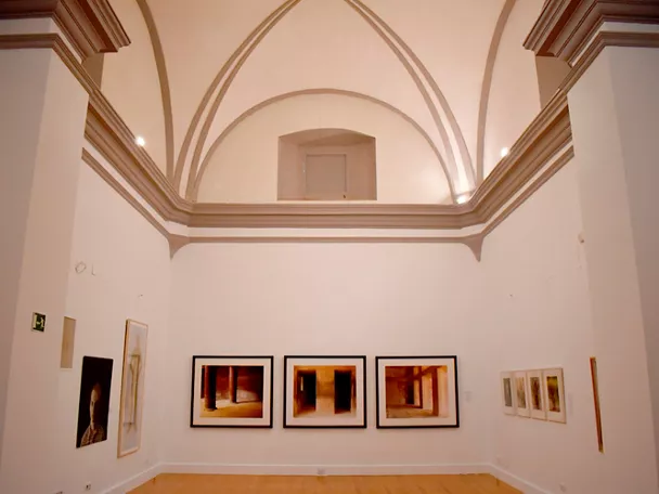 Sala de exposiciones con bóvedas y obras enmarcadas