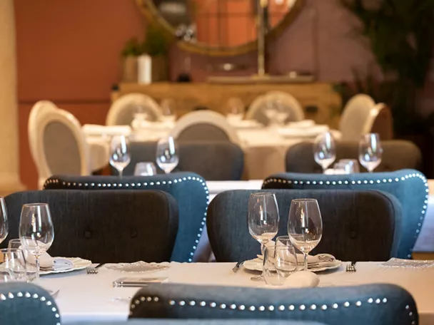 Salón elegante con mesas vestidas y sillones tapizados