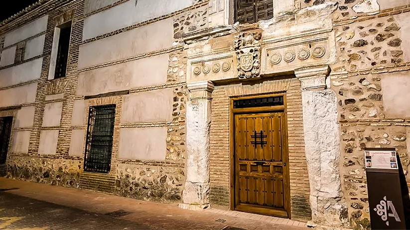 Fachada histórica de piedra con portada monumental iluminada