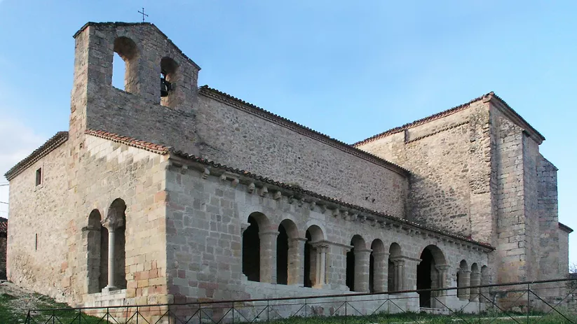 Templo románico de piedra con galería porticada.
