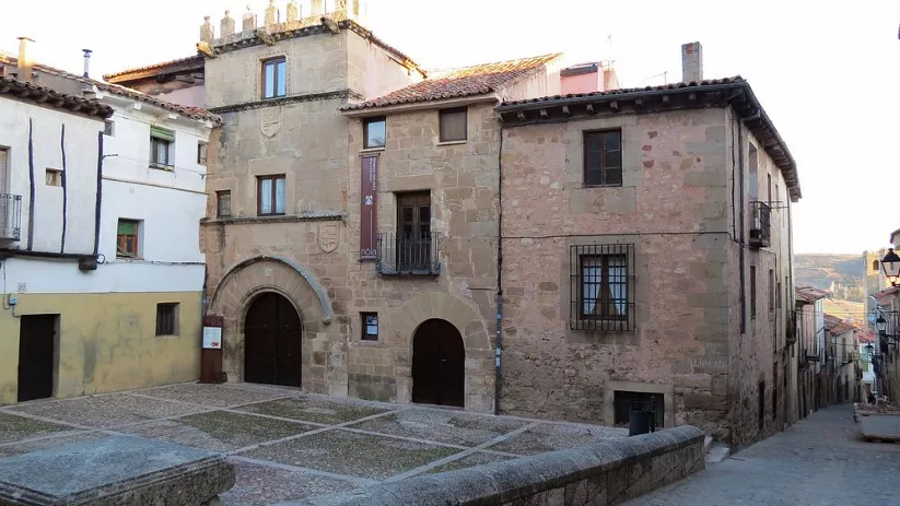 Fachada de casas de piedra en plaza empedrada.