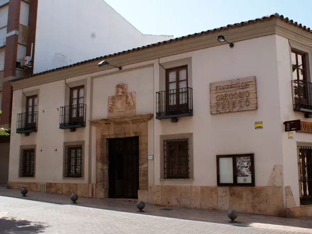 Fachada blanca con balcón y portada de piedra
