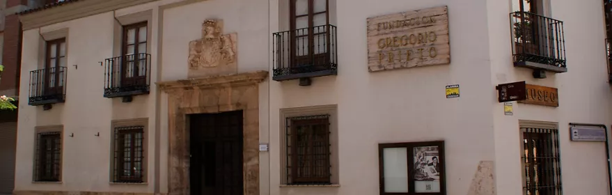 Fachada blanca con balcón y portada de piedra