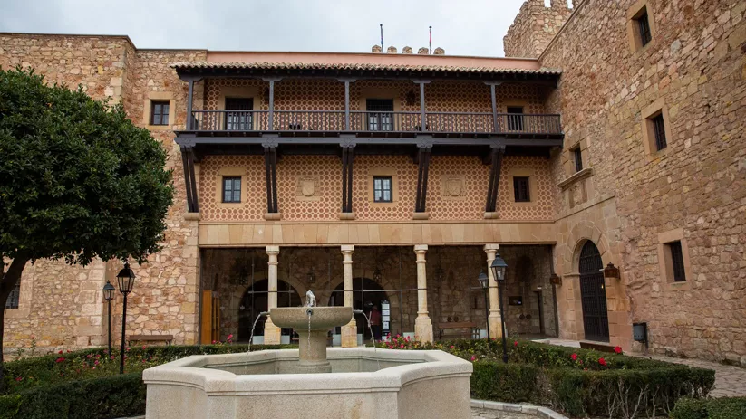 Patio interior con fuente y galería de madera.