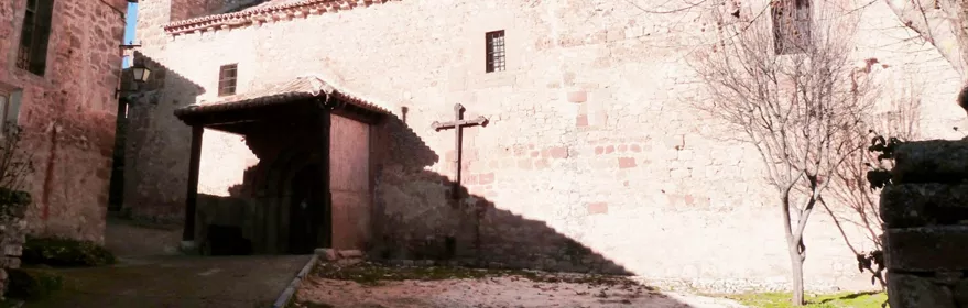 Iglesia de piedra con pórtico y espadaña.