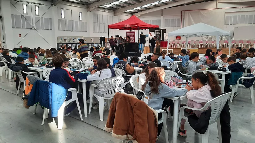 Niños participando en taller de dibujo durante evento cultural en recinto ferial.