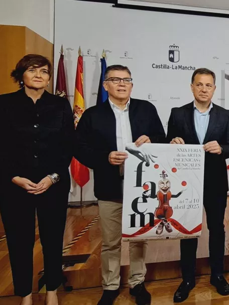 Grupo de personas presentando carteles en una sala de actos.