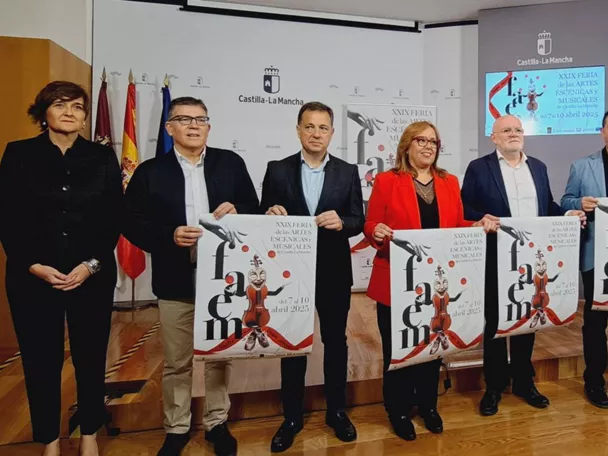 Grupo de personas presentando carteles en una sala de actos.