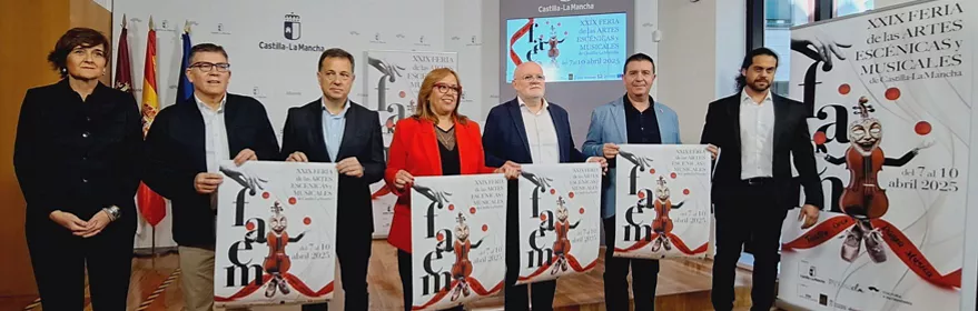 Grupo de personas presentando carteles en una sala de actos.