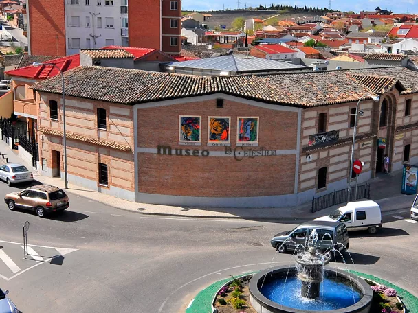 Edificio de ladrillo junto a una rotonda con fuente