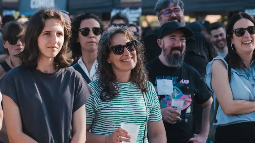 Grupo de personas sonriendo y observando un espectáculo musical.