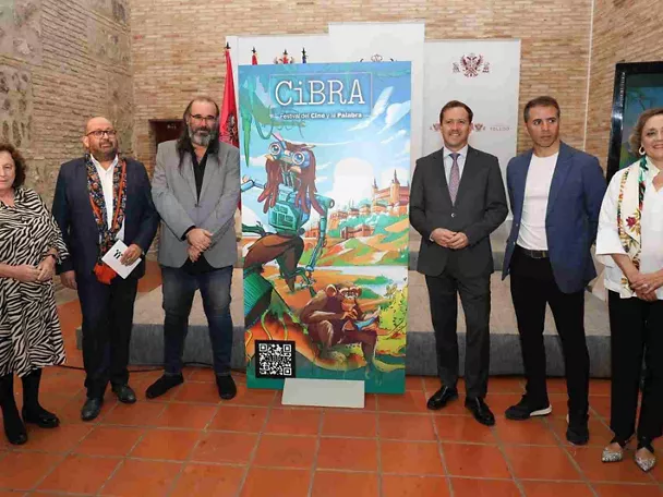 Seis personas posan junto a un cartel de festival en un patio interior