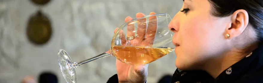 Mujer degustando vino blanco en una copa