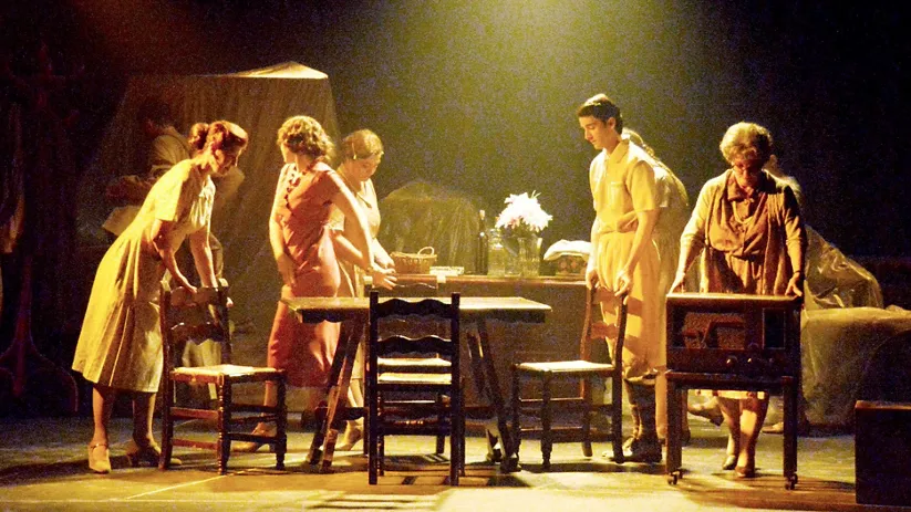 Representación teatral en escenario iluminado.