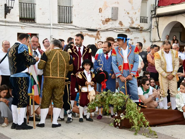 Grupo de personas con trajes tradicionales reunidas en la plaza