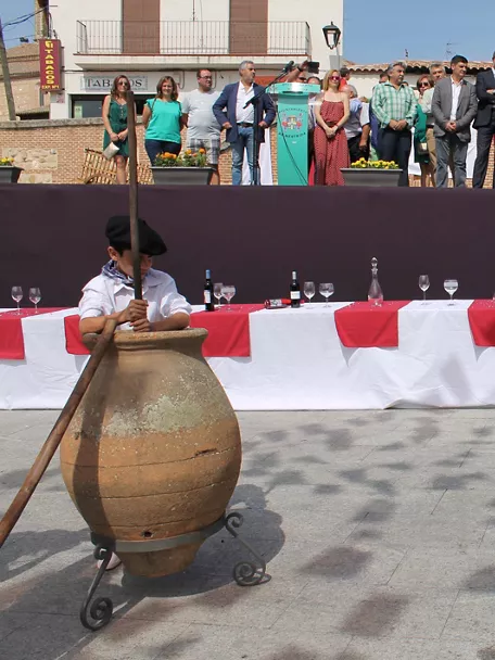 Niños participan en el pisado de uvas durante una celebración popular ante el público.