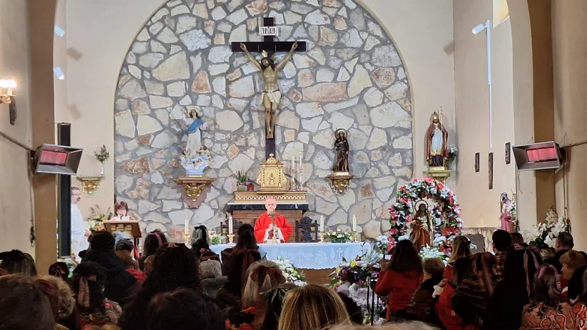 Misa en iglesia con altar decorado y asistentes.