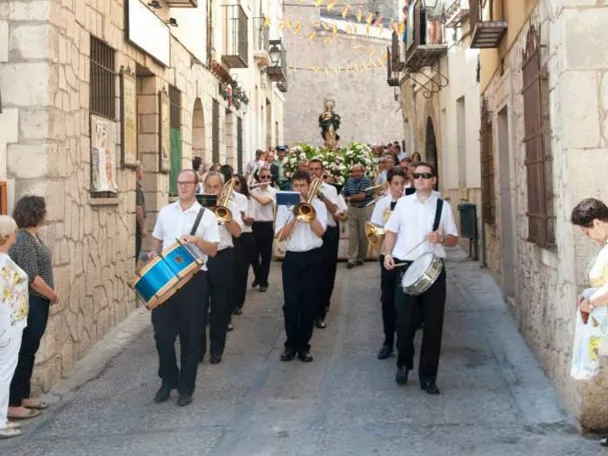 Procesión tradicional por calles históricas con banda de música y vecinos