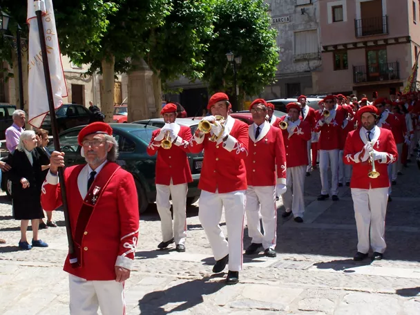 Desfile festivo con banda de música tradicional.