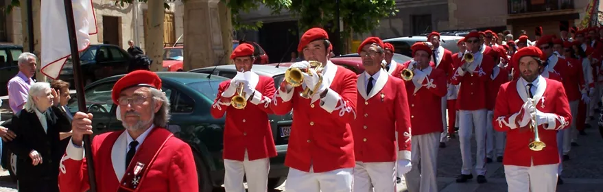 Desfile festivo con banda de música tradicional.