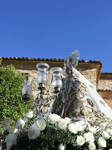 Imagen religiosa con flores blancas ante una iglesia